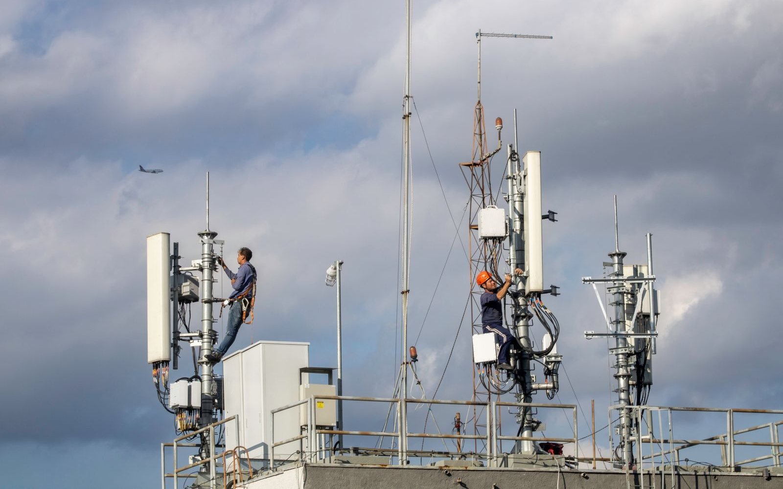 Technicians working on rooftop mobile antennas