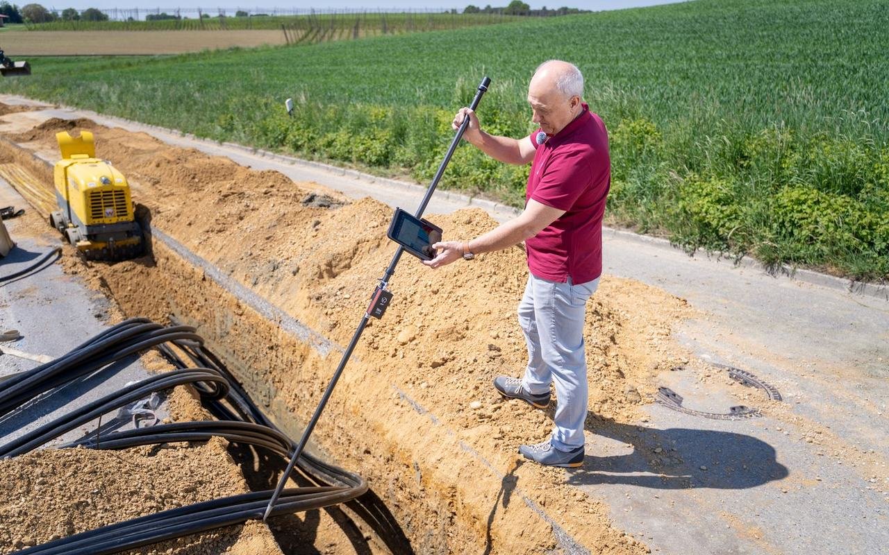 Engineer surveying a cable trench with ducts for a new fibre route