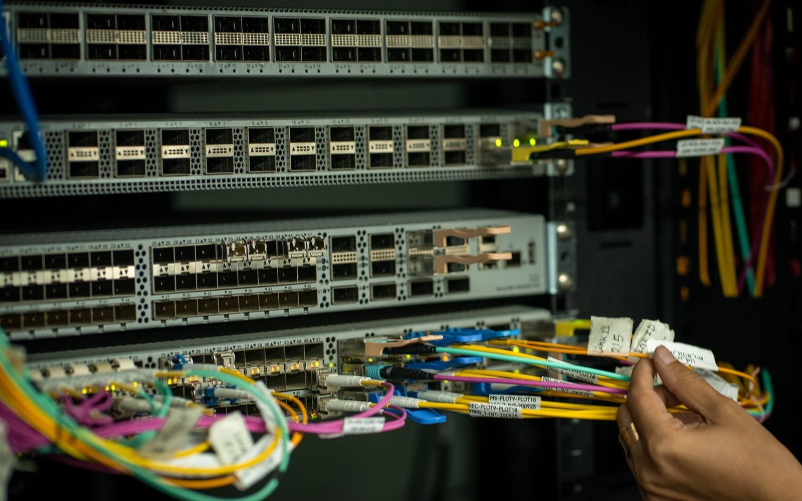 Engineer patching fibre into optical transport equipment